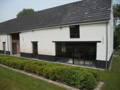 Bijgebouw met metalen schrijnwerk voorzien van dubbel glas en mastiek look afwerking. 18. Bijgebouw met metalen schrijnwerk